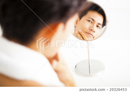 Young  man touching his smooth face after shaving 20326453
