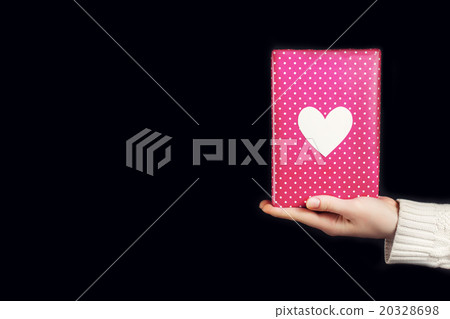 Hand holding pink gift isolated on black Hand holding pink gift isolated on black 20328698