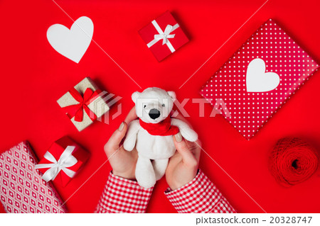 woman holding white bear on red 20328747