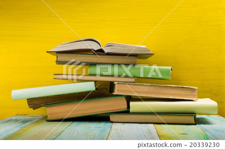 Stack of hardback books, diary on wooden deck 20339230