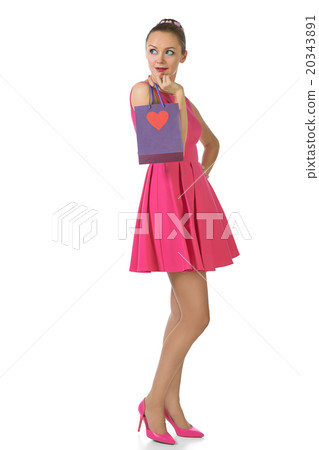 Pretty blond woman in pink dress holding gift bag Pretty blond woman in pink dress holding gift bag 20343891