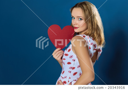 Profile pretty blond girl holding red paper heart Profile pretty blond girl holding red paper heart 20343916