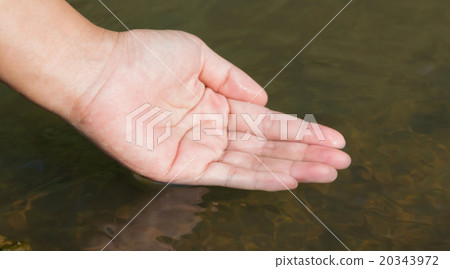 a hand dip into natural water 20343972