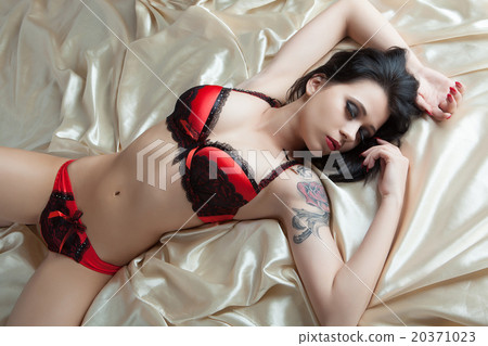 Woman Laying Down On A Bed With Black Lingerie And Red Lipstick