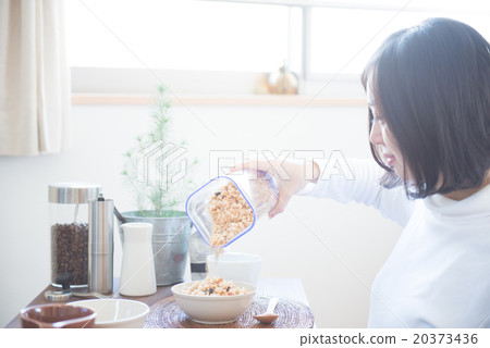 A woman eating cereal A woman eating cereal 20373436