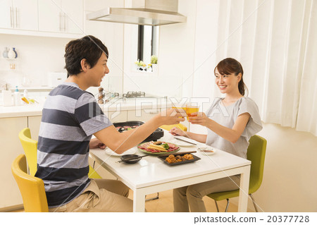 A young couple who roasts grilled meat on a hot plate A young couple who roasts grilled meat on a hot plate 20377728
