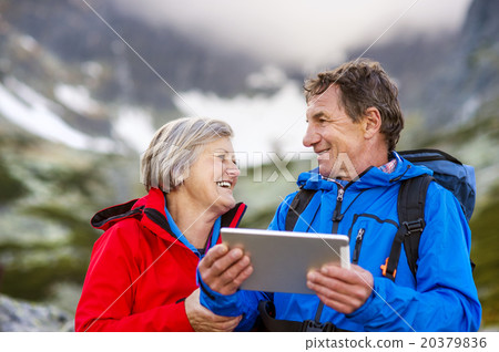 Senior hikers couple with tablet 20379836