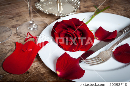 Table setting with red roses on plate  20392748