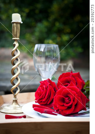 Table setting with red roses on plate  20392773