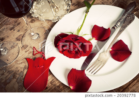 Table setting with red roses on plate  20392778