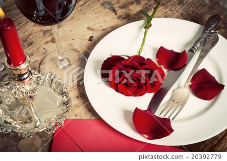 Table setting with red roses on plate  20392779