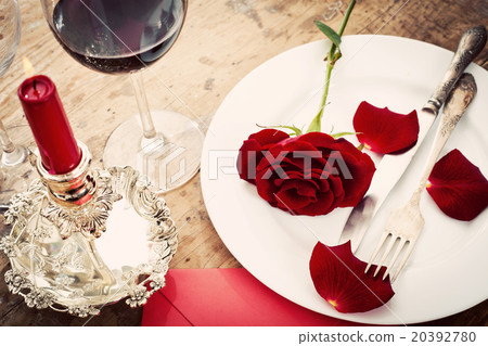 Table setting with red roses on plate  20392780