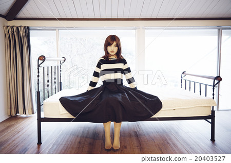 A woman sitting on a bed 20403527