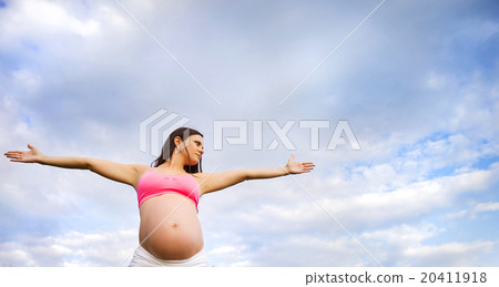 Pregnant woman exercising in nature 20411918