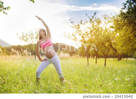 Pregnant woman exercising in nature Pregnant woman exercising in nature 20413048
