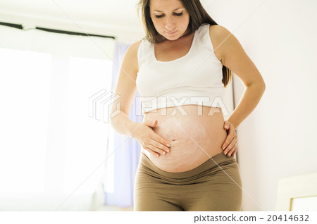 Pregnant woman appyling cream Pregnant woman appyling cream 20414632