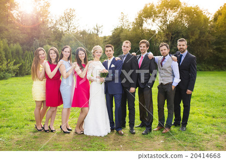 Newlyweds with guest posing in park 20414668