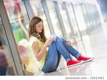 Girl with smartphone in shopping mall Girl with smartphone in shopping mall 20415461