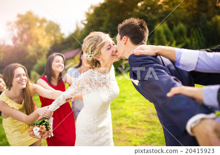 Newlyweds kissing in park 20415923