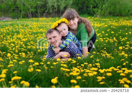 Young family walking on the meadow with yellow flowers in spring Young family walking on the meadow with yellow flowers in spring 20428718