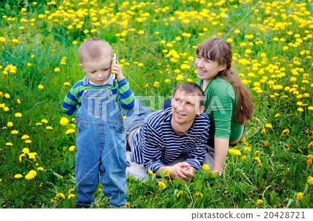 Young family walking on the meadow with yellow flowers in spring Young family walking on the meadow with yellow flowers in spring 20428721