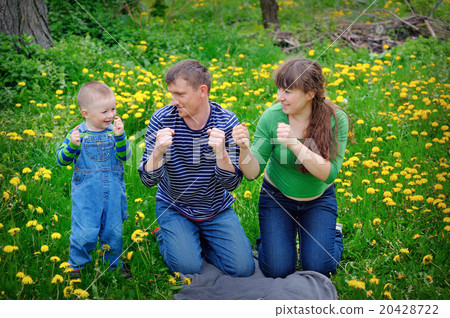 Young family walking on the meadow with yellow flowers in spring Young family walking on the meadow with yellow flowers in spring 20428722