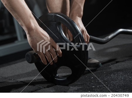 Man preparing barbell at gym class 20430749