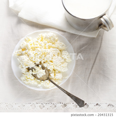 Dish of cottage cheese, a mug of milk on a white b 20431315