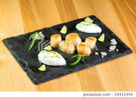 Studio close up of seared scallops, garnished  20431494