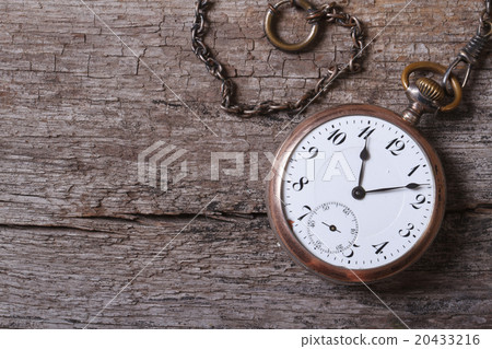 old gold pocket watch on a chain on an old wooden old gold pocket watch on a chain on an old wooden 20433216