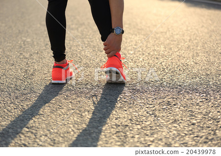 woman runner hold her injured leg on road 20439978
