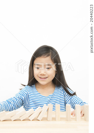 使用在多米諾構建塊的女孩演奏小學女孩多米諾構件 20440223