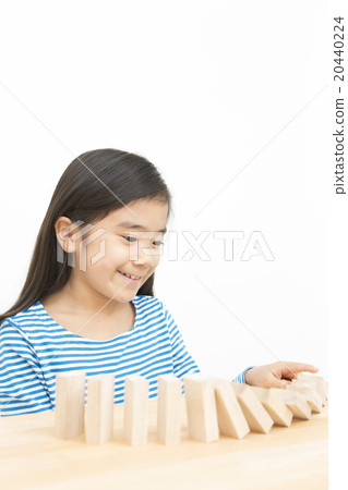 使用在多米諾構建塊的女孩演奏小學女孩多米諾構件 20440224