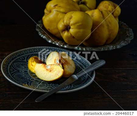 cut fruit quince on a plate, a knife on a wooden b cut fruit quince on a plate, a knife on a wooden b 20446017