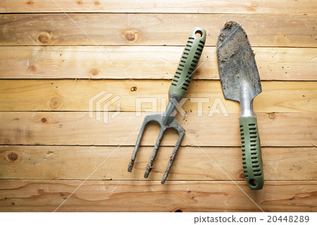Small gardening shovel and fork on wooden. 20448289