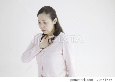 Woman in her forties Pushing her chest as she looks breathing Natural light white back 20451656