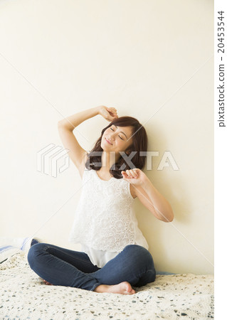 A woman relaxing in bed A woman relaxing in bed 20453544