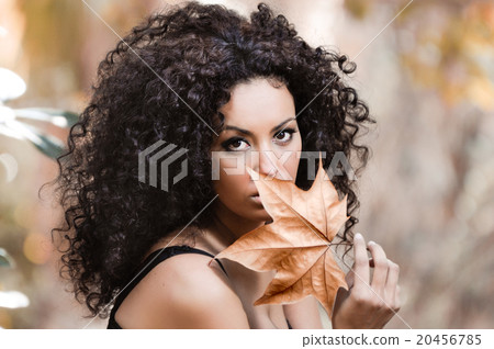 Young african woman siting on bench in park 20456785