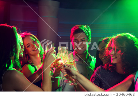 smiling friends with glasses of champagne in club smiling friends with glasses of champagne in club 20460468