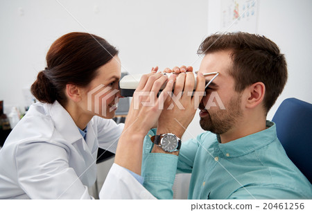 optician with pupilometer and patient at eye clinic optician with pupilometer and patient at eye clinic 20461256