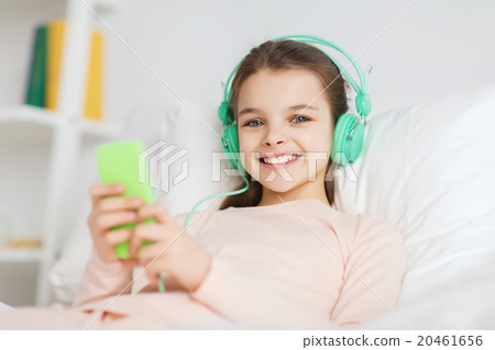 happy girl lying in bed with smartphone at home happy girl lying in bed with smartphone at home 20461656
