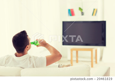 man watching tv and drinking beer at home man watching tv and drinking beer at home 20461819