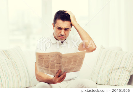 sad man reading newspaper at home sad man reading newspaper at home 20461906