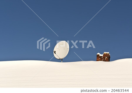 Satellite antenna and chimney on snowy roof. 20463544