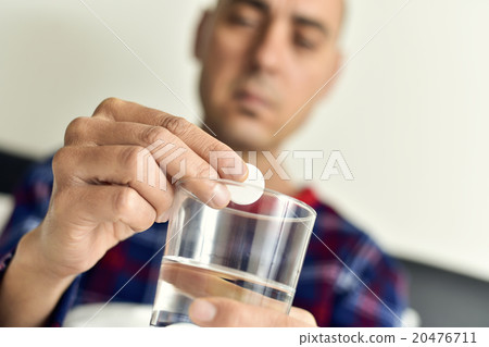 putting an effervescent tablet in glass with water 20476711
