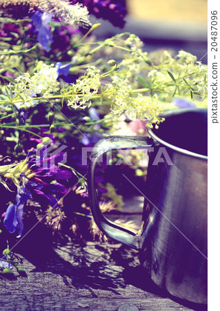 hiking mug on a wooden table with cut flowers hiking mug on a wooden table with cut flowers 20487096