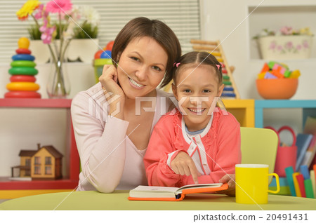 Daughter and mother reading the book Daughter and mother reading the book 20491431