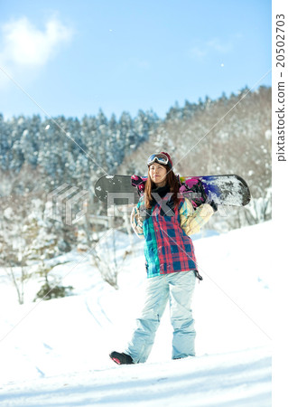 A woman enjoying snowboarding on the slopes 20502703