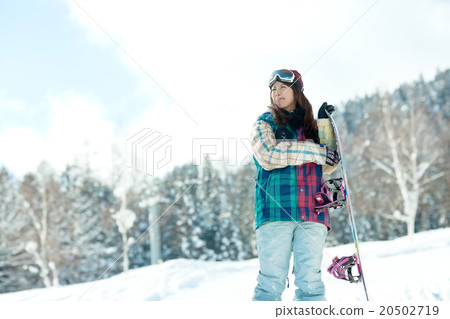 A woman enjoying snowboarding on the slopes A woman enjoying snowboarding on the slopes 20502719