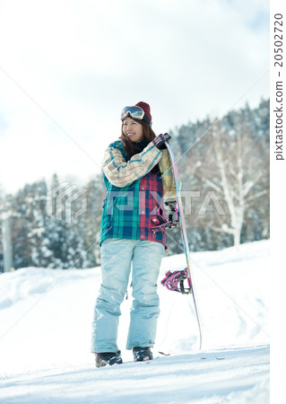 A woman enjoying snowboarding on the slopes A woman enjoying snowboarding on the slopes 20502720